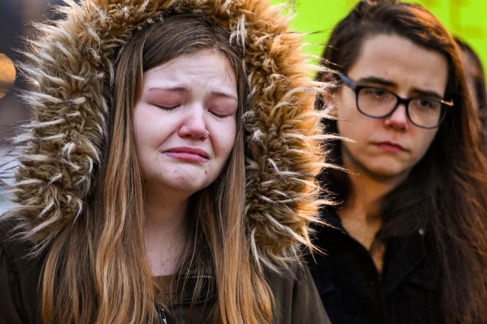 Rebecca Carr, of Mastic, left, sheds a tear
