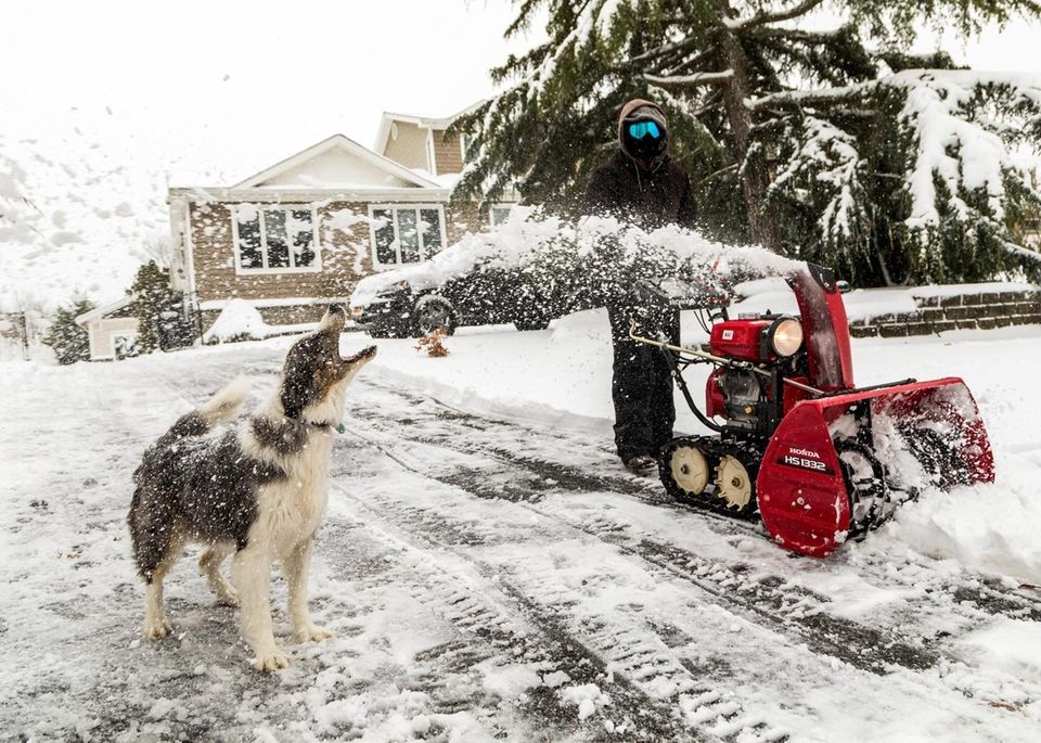 Paul Zucconi uses a snow blower to clear