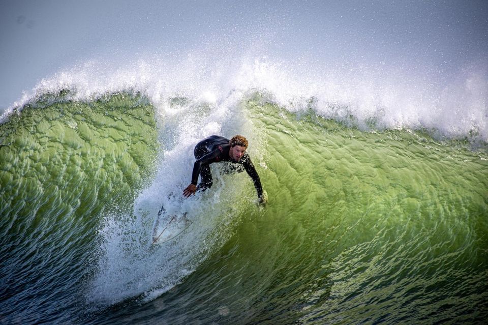 A surfer rides the large waves at Lido