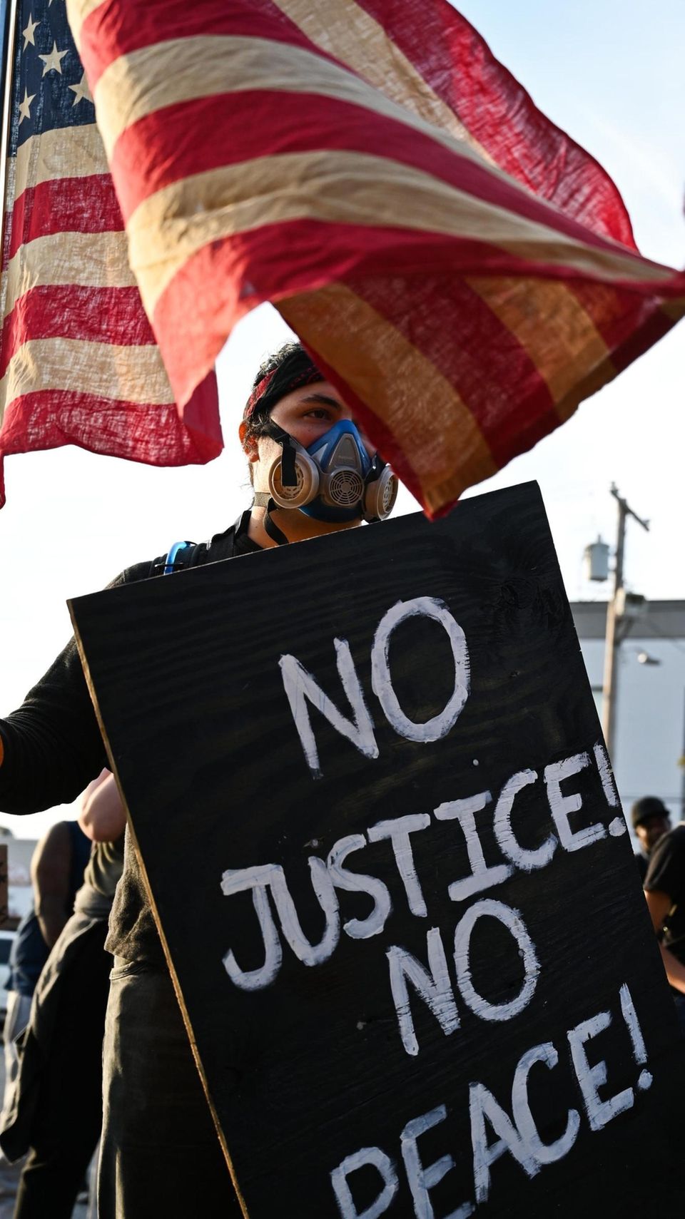'Aleki Lui, of Riverhead, holds a sign and