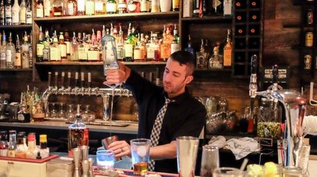 Bartender mixes cocktails behind the bar of Vauxhall