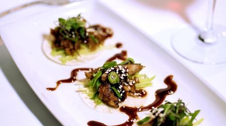 An appetizer of Peking duck is prepared with
