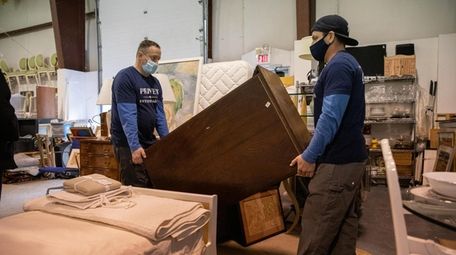 Privet Warehouse employees carry a dresser at an