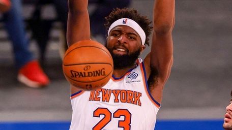 Knicks center Mitchell Robinson dunks in front of