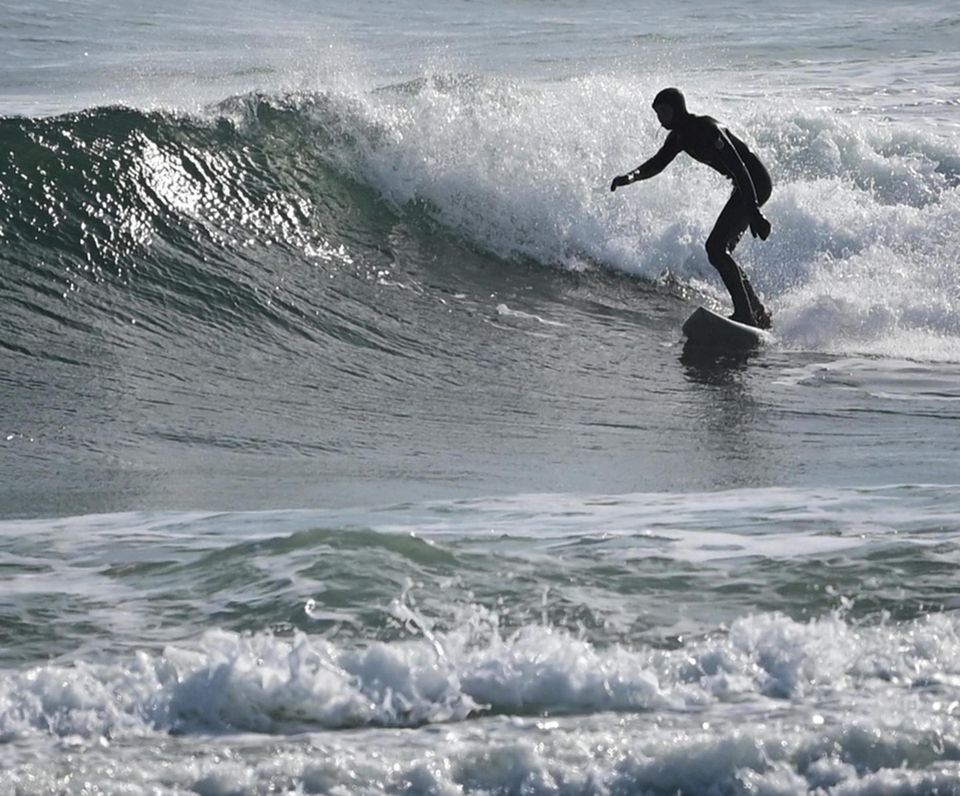 Surfers catch waves in the waters off of