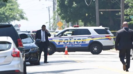 Suffolk police detectives work the scene near a