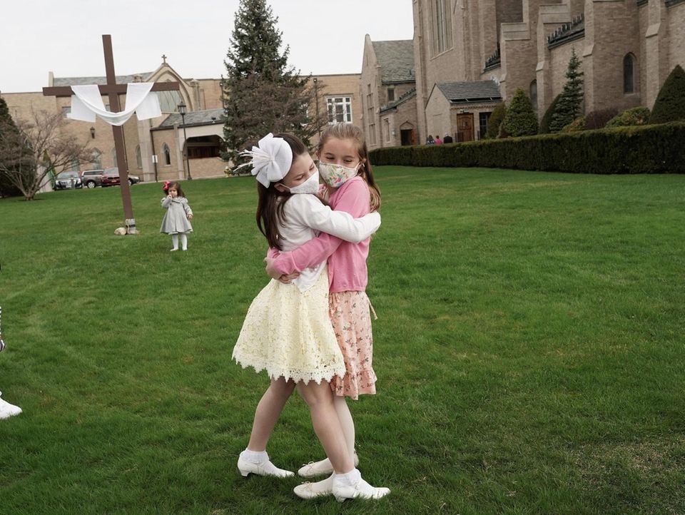 Parishioners Caroline Lennon, 8, 2nd right, hugs her