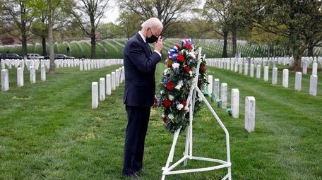 President Joe Biden makes a sign of the