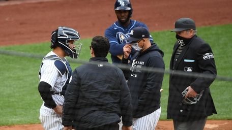 Yankees catcher Gary Sanchez is checked on by