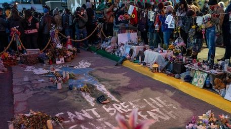 Demonstrators gather around the pavement where George Floyd