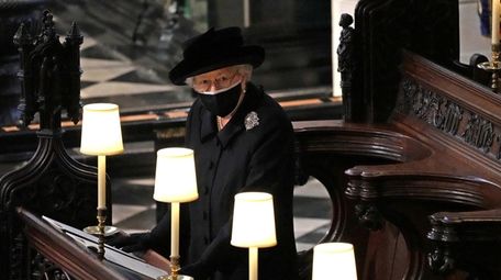 Queen Elizabeth II watches as pallbearers carry the