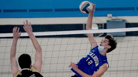 Calhoun's Owen Rose (12) spikes the ball past