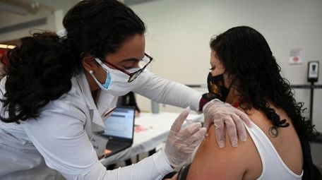 Molloy College nursing student Ana Quintanilla vaccinates Gabriela