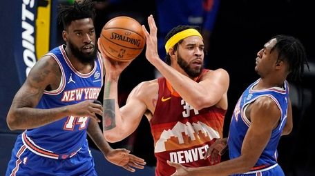 Nuggets center JaVale McGee, center, passes the ball