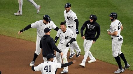 Yankees' Gleyber Torres, center, is congratulated by teammates
