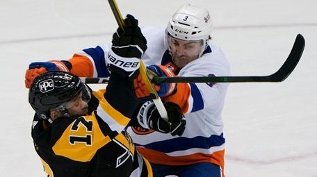 The Islanders' Adam Pelech checks the Penguins' Bryan