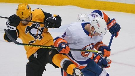 The puck slides under the Penguins' Colton Sceviour