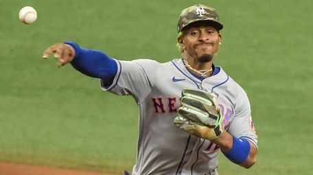 Mets shortstop Francisco Lindor, right, throws to first