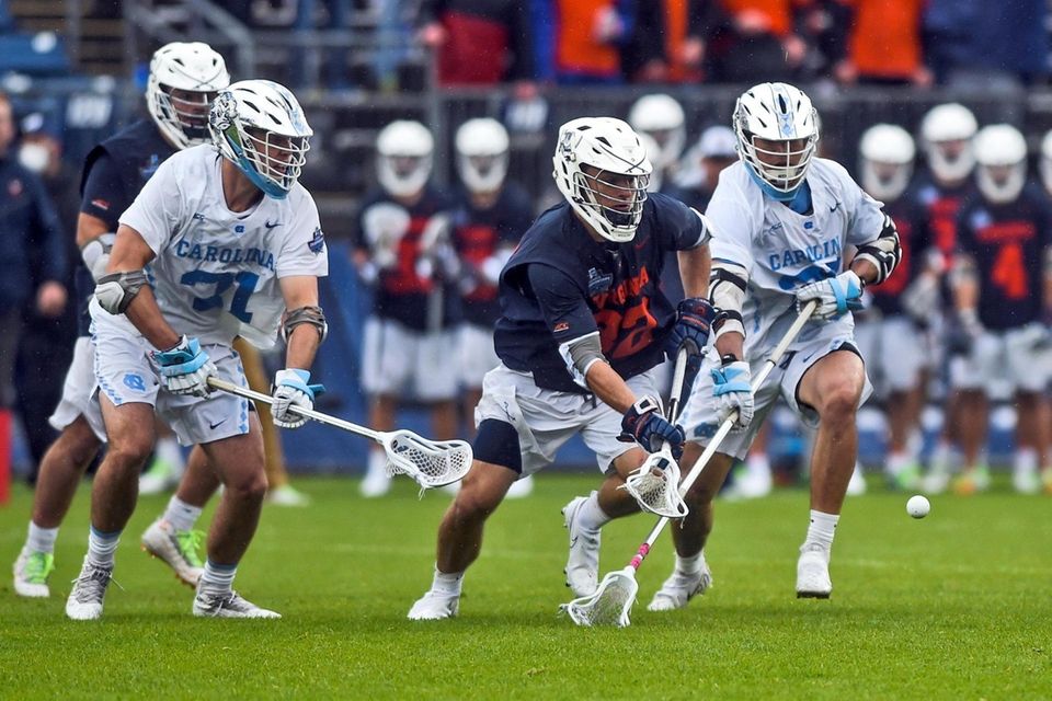 Virginia's Grayson Sallade, center, is defended North Carolina