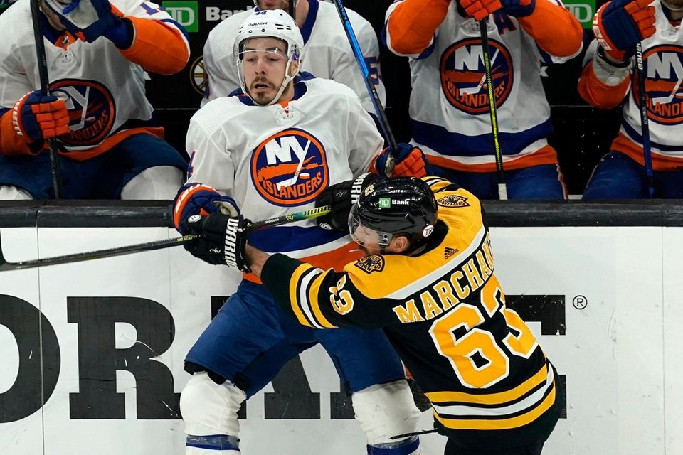 Boston Bruins center Brad Marchand (63) checks New