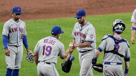 Mets manager Luis Rojas (19) takes the ball