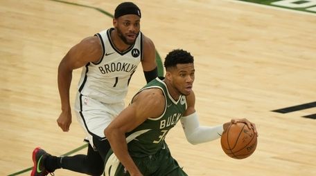 The Bucks' Giannis Antetokounmpo drives past the Nets'