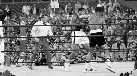 Muhammad Ali, center, tries to avoid a left