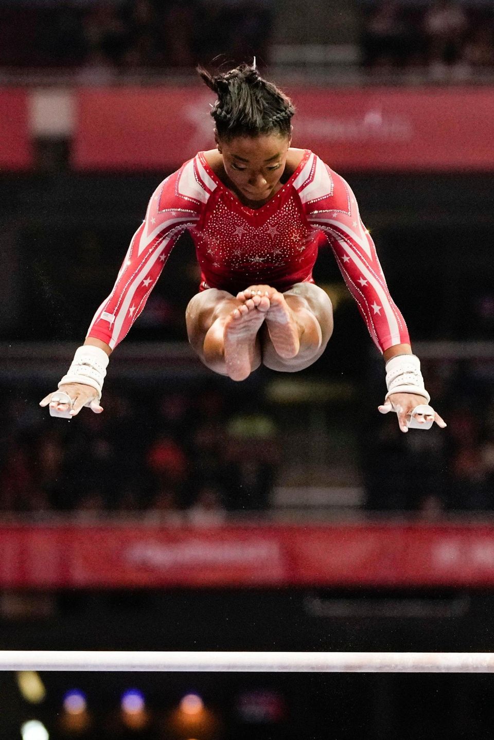 Simone Biles competes on the uneven bars during