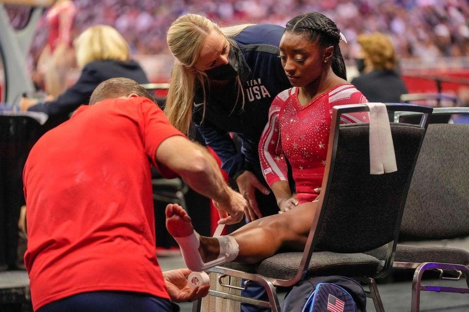 Simone Biles has her ankle taped after falling