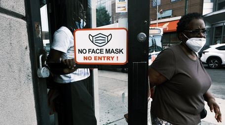 People walk out of a store in Brooklyn