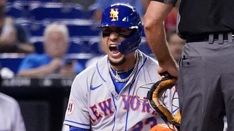 The Mets' Javier Baez, left, reacts after scoring
