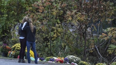 People mourn at the site of the limousine
