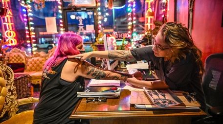 Tattoo artist and shop owner Cory Good consults