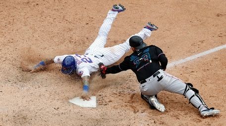 Javier Baez #23 of the Mets slides home