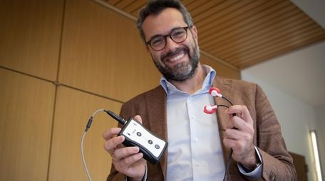 Feinstein Institutes researcher Theodoros Zanos holds a prototype