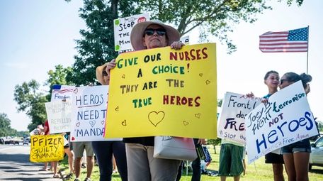 Health care workers protest mandatory vaccinations outside the