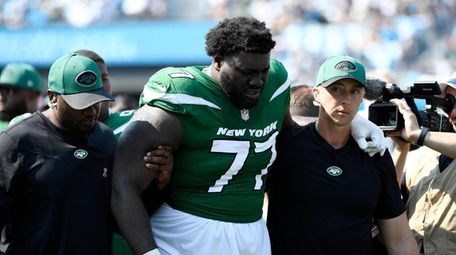 Mekhi Becton #77 of the Jets is helped