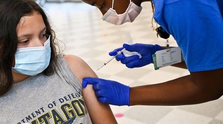 Tatiana Majano, 13, of Freeport, is administered a