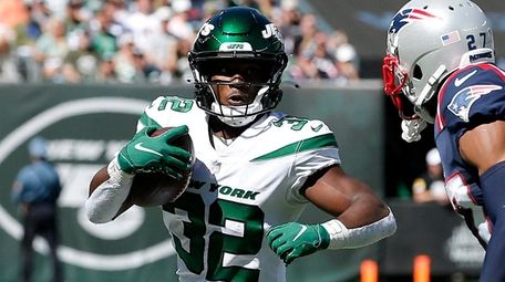 Michael Carter #32 of the Jets runs the