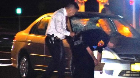 Suffolk County police investigate the scene where a