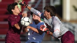James Castoro, Garden City goalie, right, comes out