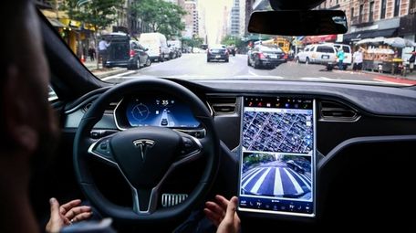A driver rides hands-free in a Tesla Motors