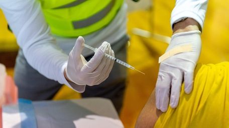 A health care worker administers a dose of