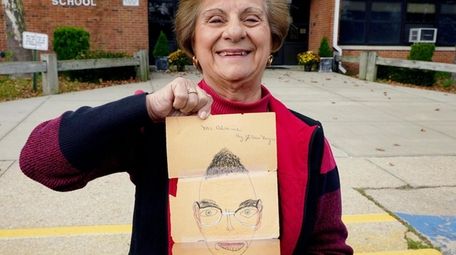JoAnn Nigro-Guido holds a portrait she drew of