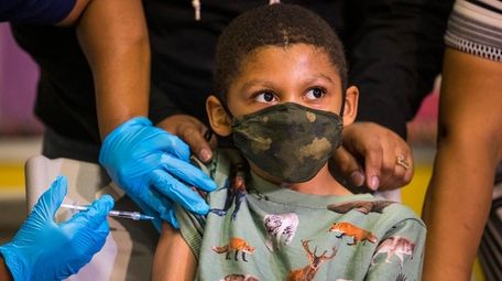 Christopher Reyes, 9, gets a COVID-19 vaccination at