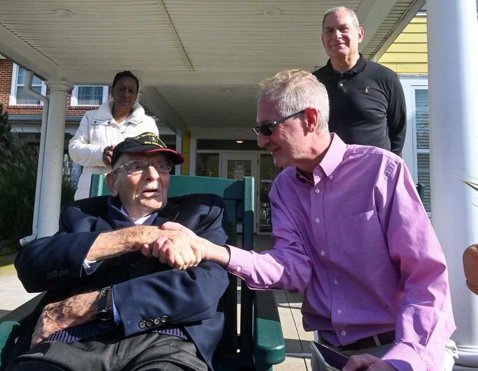 Army veteran Frank Wolff, 100, shakes hands with