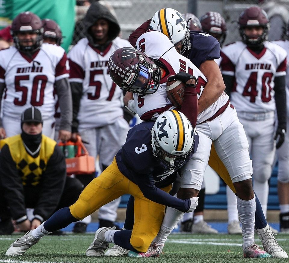 Chris Silverio of Whitman gets tackled by Massapequa's
