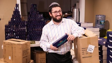 Rabbi Mendel Teldon holds a menorah surrounded by