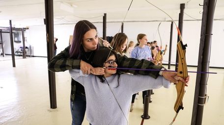 Instructor Deanna Dykstra assists Kate Hebron, 10, of