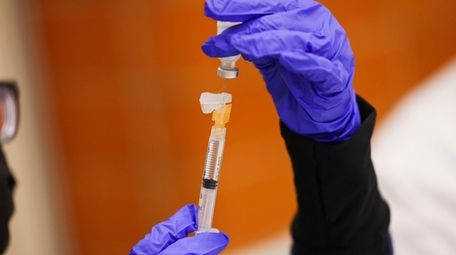 A Pfizer-BioNTech COVID-19 vaccine booster shot is prepped